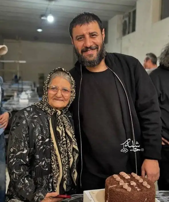 تصویر - لبخند جالب جواد عزتی حین گرفتن عکس یادگاری با بازیگر نقش مادرش در پشت صحنه یک سریال
